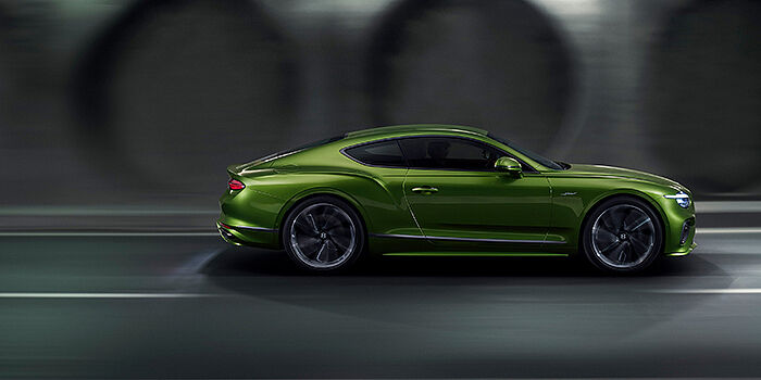 Bentley Kaohsiung Bentley Continental GT coupe in Tourmaline Green paint driving in profile on a dark road