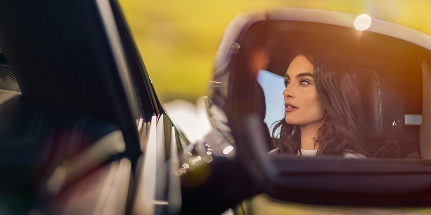 Bentley Kaohsiung profile of dark haired woman's face in mirror of Bentley car in sunlight