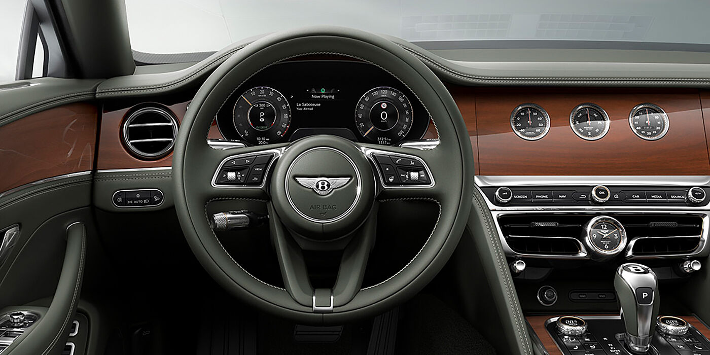 Bentley Kaohsiung New Bentley Flying Spur sedan front cabin in Cumbrian Green hide and Crown Cut walnut veneer showing steering wheel and Rotating Display with three clocks on face