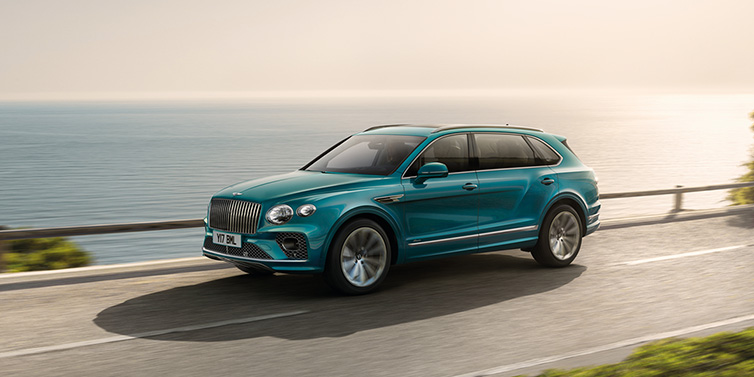 Bentley Kaohsiung Bentley Bentayga Extended Wheelbase Azure SUV in Topaz blue paint driving dynamically by the ocean