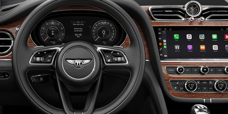 Bentley Kaohsiung Bentley Bentayga SUV front interior detail of steering wheel and driver screens surrounded by Beluga black hide and Crown Cut Walnut veneer