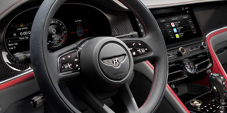 Bentley Kaohsiung Bentley Flying Spur Speed sedan front interior detail showing steering wheel and driver screens surrounded with Hotspur red and Gravity Grey hides